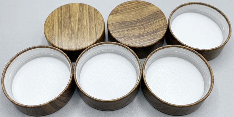 Wood grain cosmetic caps and soft-touch coated lids