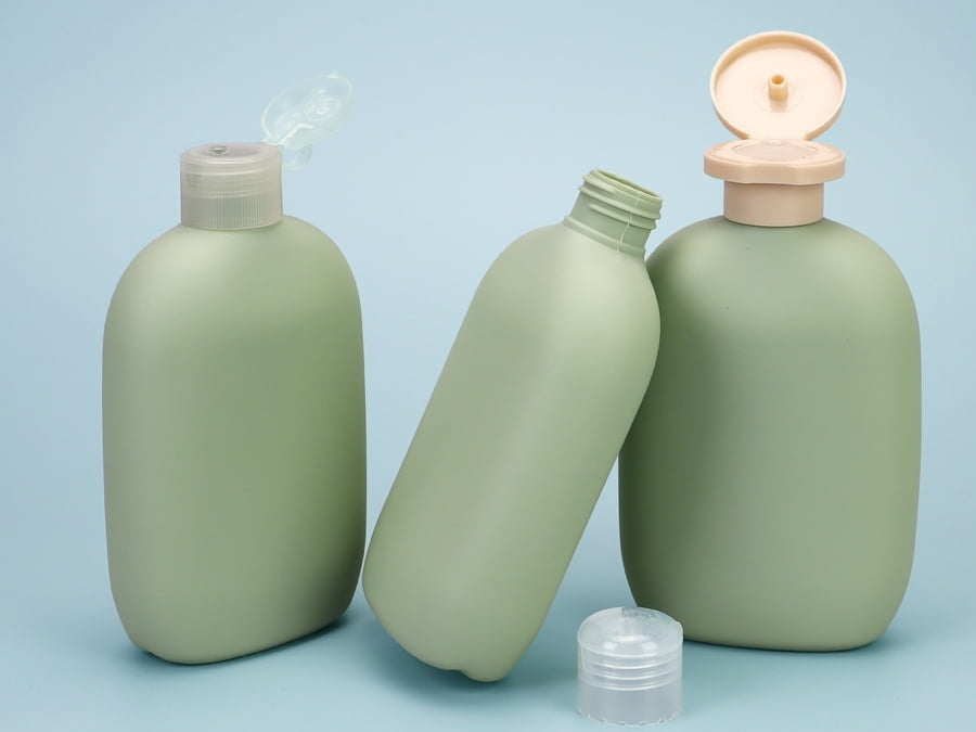 Green cosmetic bottles with open flip-top caps and an exposed threaded bottle neck.