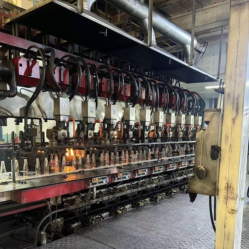 Glass bottles on production equipment in a cosmetic packaging workshop
