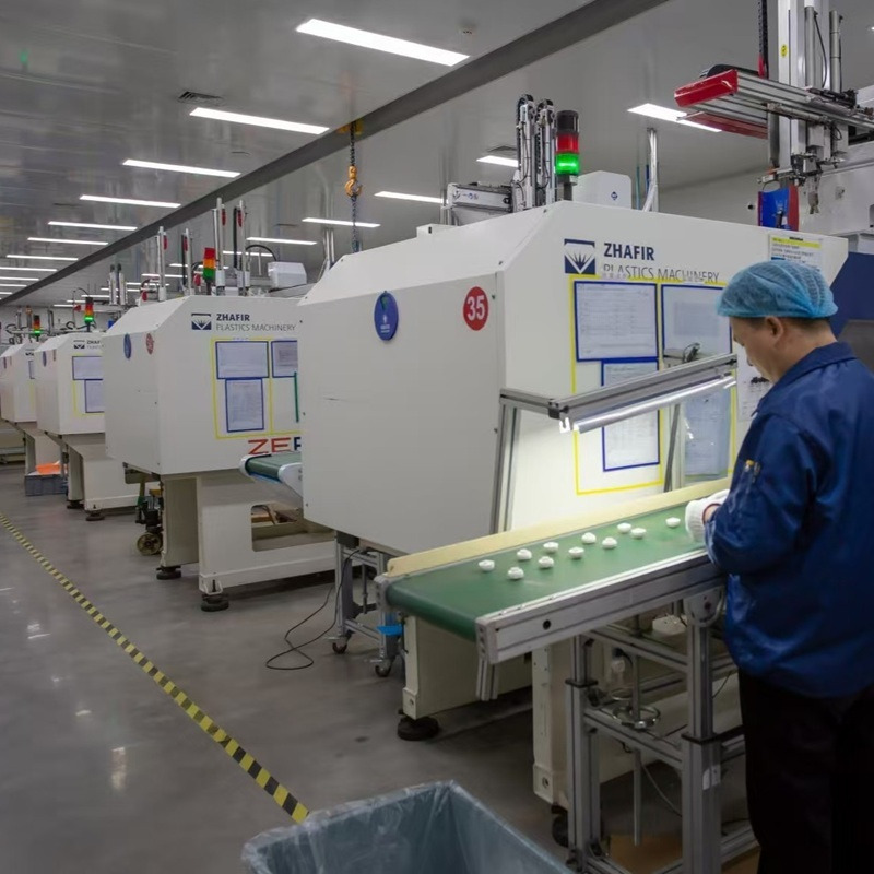 Injection molding equipment and a worker handling cosmetic packaging components
